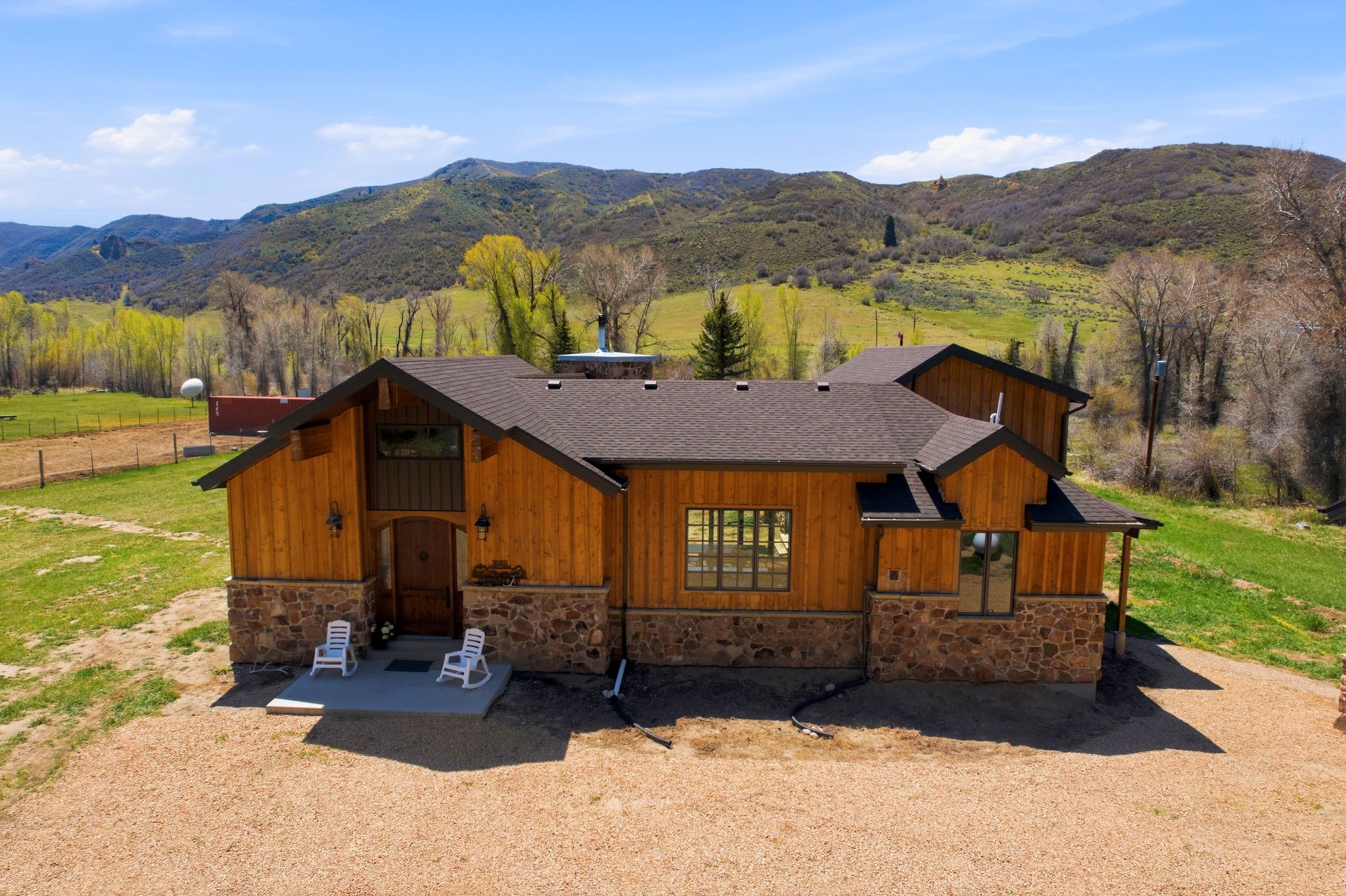 Craftsman-style residence featuring natural wood siding and a stone foundation