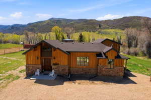 Craftsman-style residence featuring natural wood siding and a stone foundation