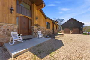Stone and wood-sided exterior featuring an arched entry door with sidelights