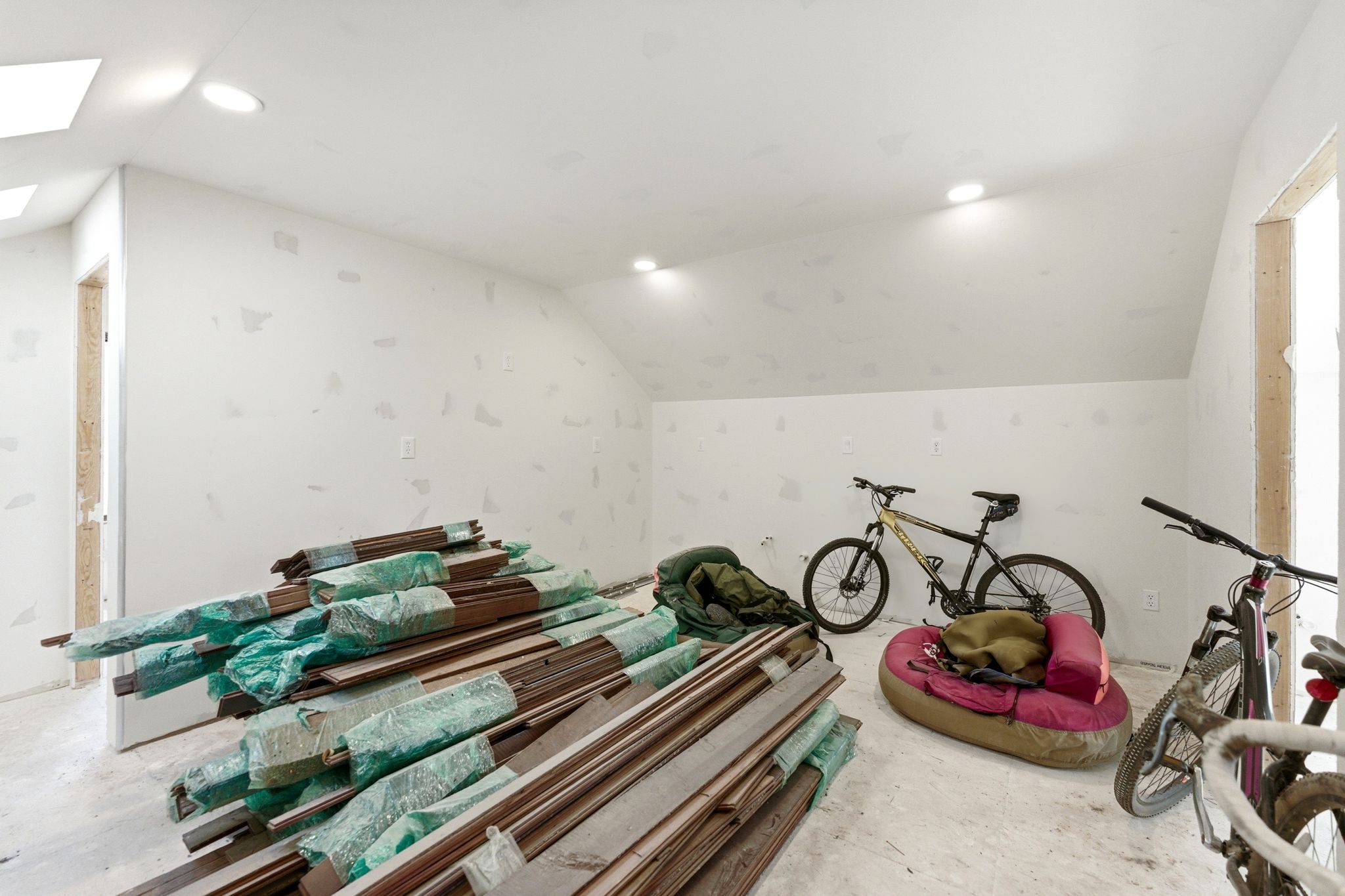 Expansive attic space featuring a sloped ceiling, recessed lighting, and a skylight