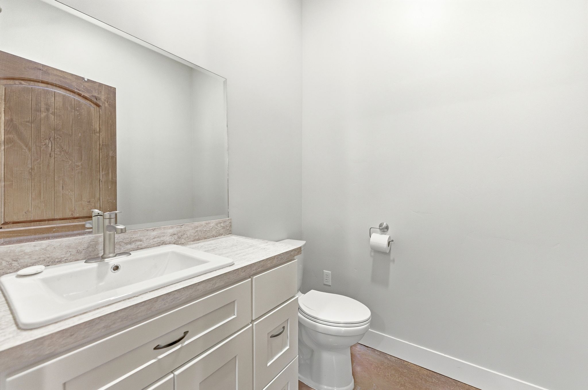 Modern bathroom vanity featuring white shaker-style cabinetry, an integrated white sink, and a brushed nickel faucet