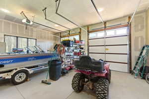 Spacious garage with multiple overhead doors, high ceilings, and recessed lighting