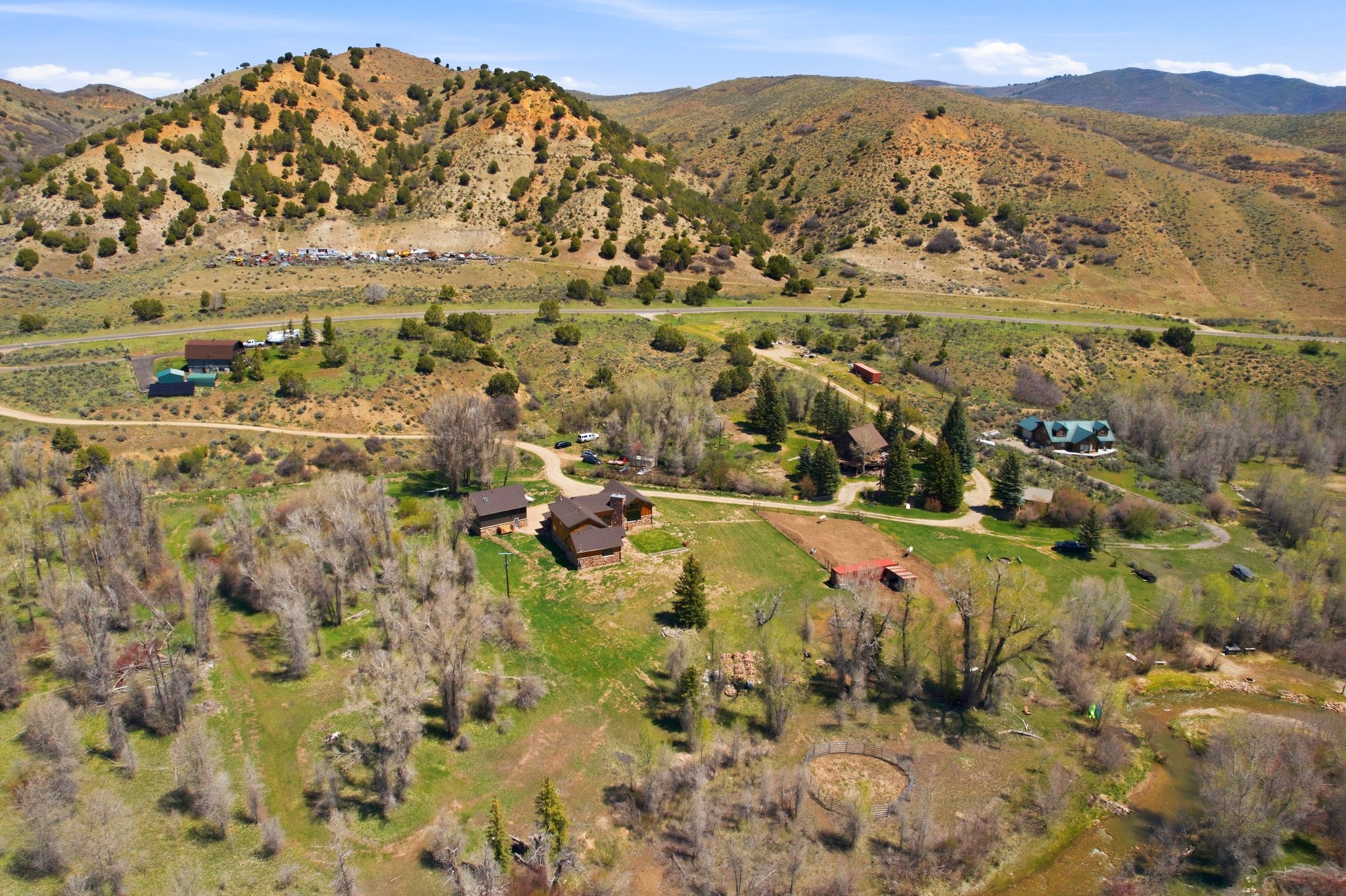 Expansive rural property featuring multiple residences, mature trees, and natural waterways
