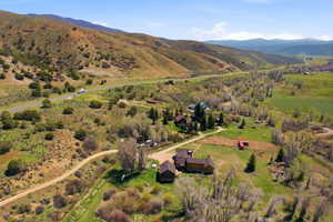 Rural property featuring multiple structures, extensive surrounding acreage, and a winding dirt road