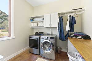 Dedicated laundry space featuring a window, built-in shelving, white cabinetry, a clothing rod, and a wood-finish countertop