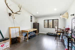 Spacious room with dark wood-finish flooring, recessed lighting, and a large multi-pane window