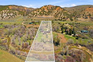Expansive property featuring a winding river, mature trees, and mountainous terrain