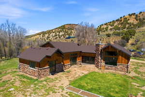 Contemporary property with natural wood siding and stone veneer, featuring a prominent stone chimney