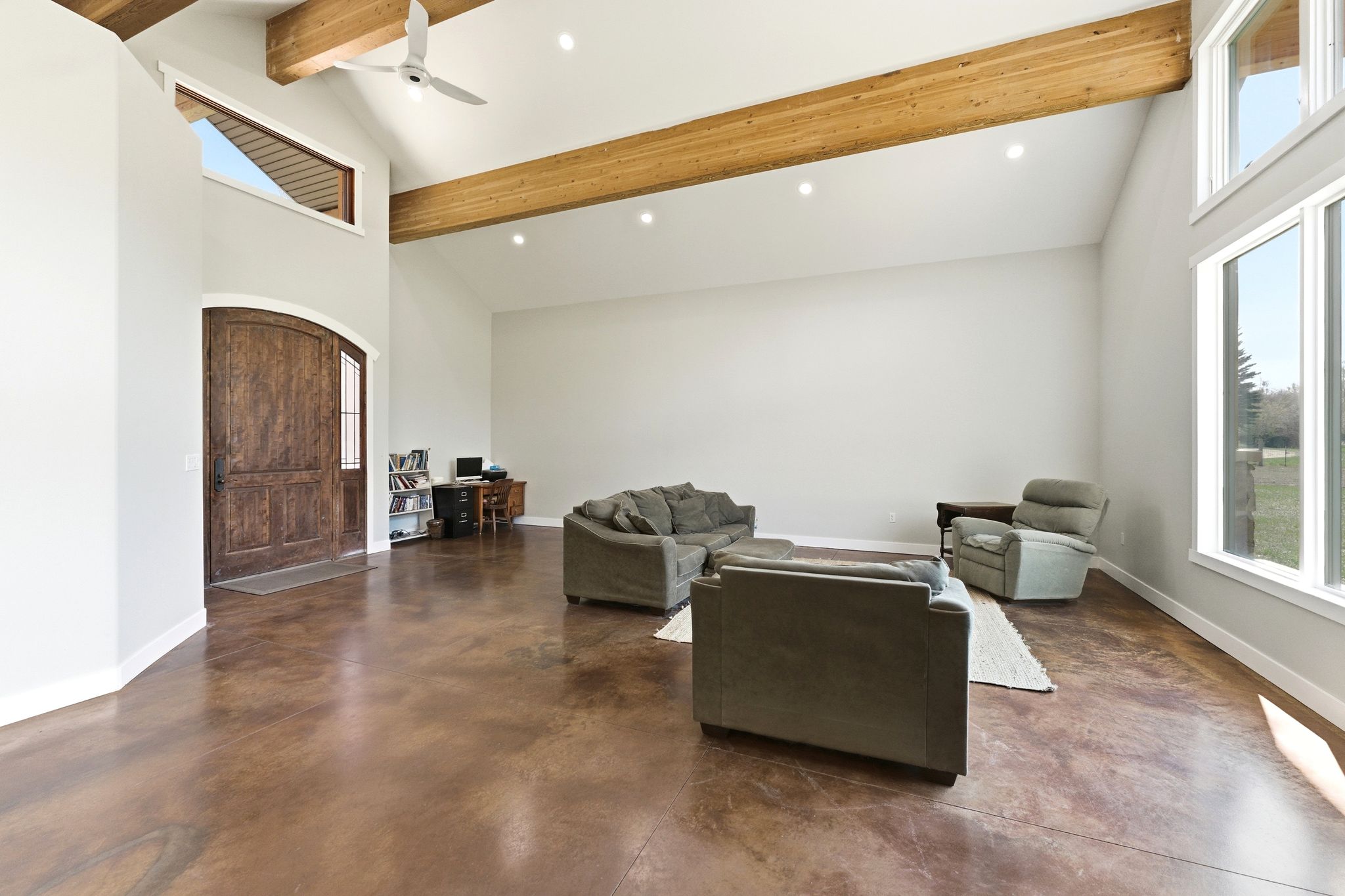 Vaulted ceiling great room featuring exposed wood beams, recessed lighting, and expansive windows