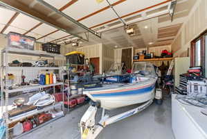 Spacious garage featuring high ceilings, exposed beams, and multiple windows providing natural light