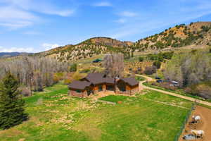 Rustic-style residence featuring a brown shingled roof and stone and wood-paneled exterior