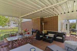 Expansive covered deck featuring a textured metal roof, string lighting, and wood-finish flooring