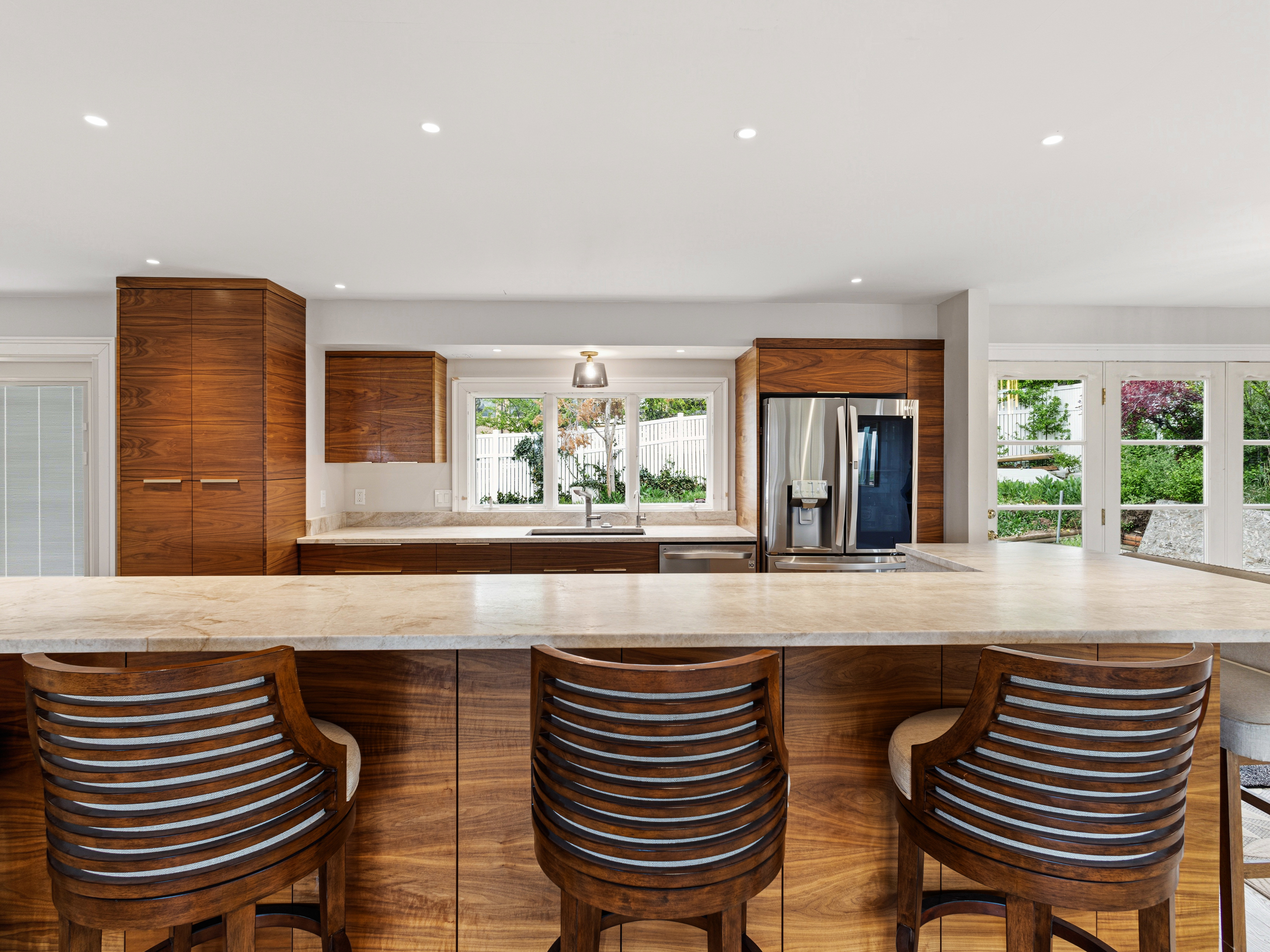 Kitchen featuring an expansive countertop island, wood-finish cabinetry, recessed lighting, and stainless steel appliances