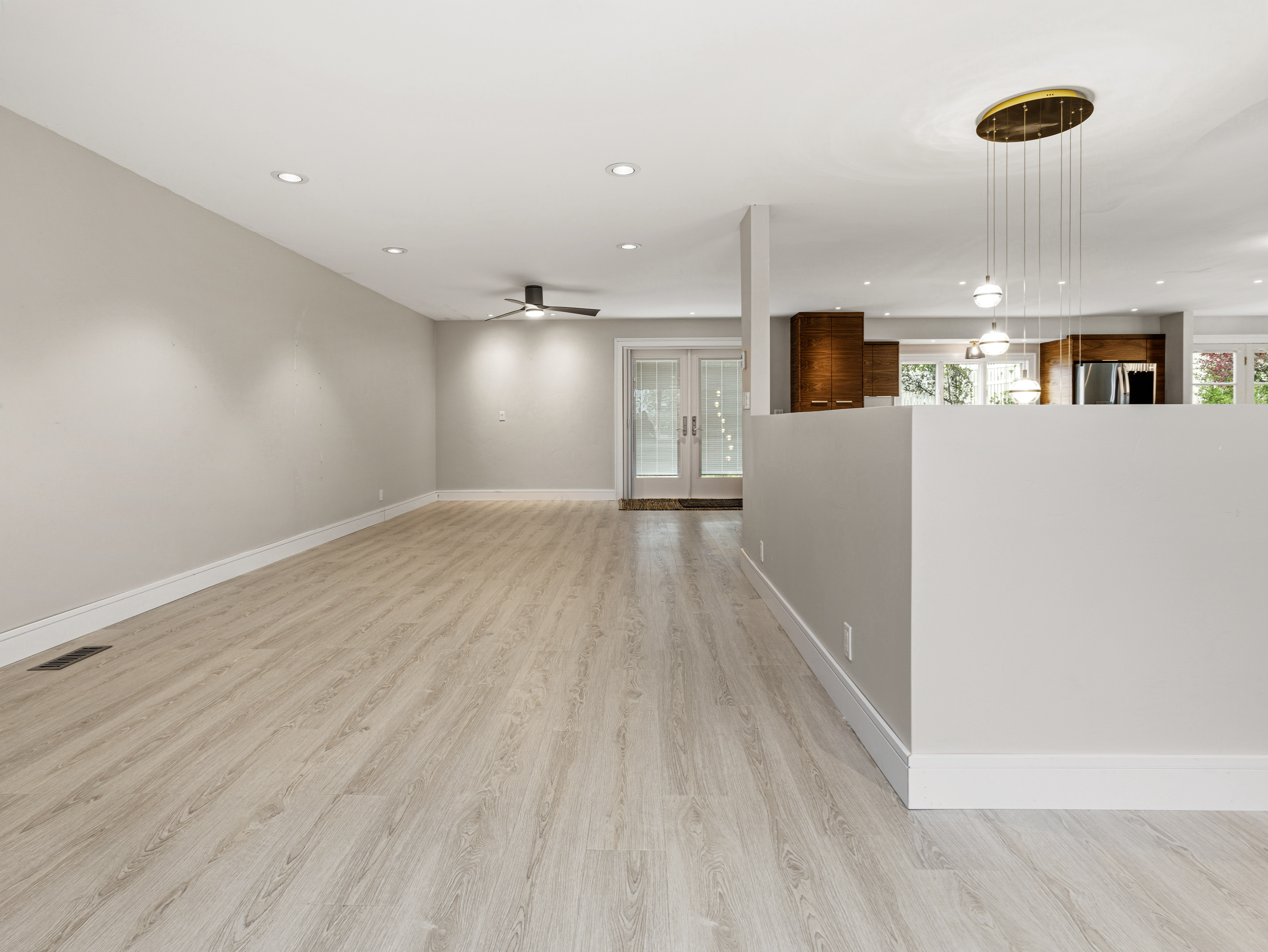 Spacious interior featuring wood-finish flooring, recessed lighting, and a contemporary ceiling fan