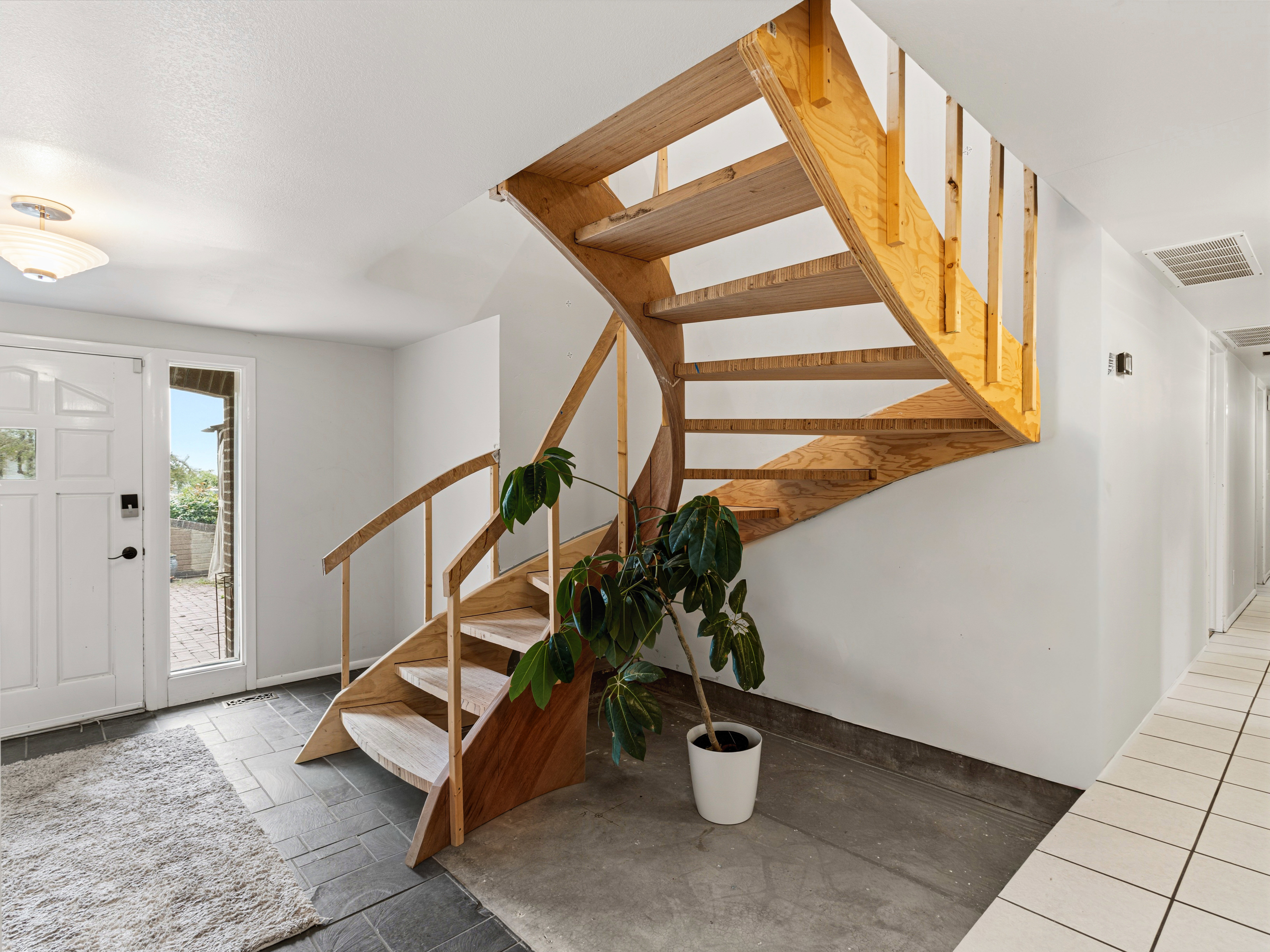 Spiral staircase with wood-finish treads and balusters