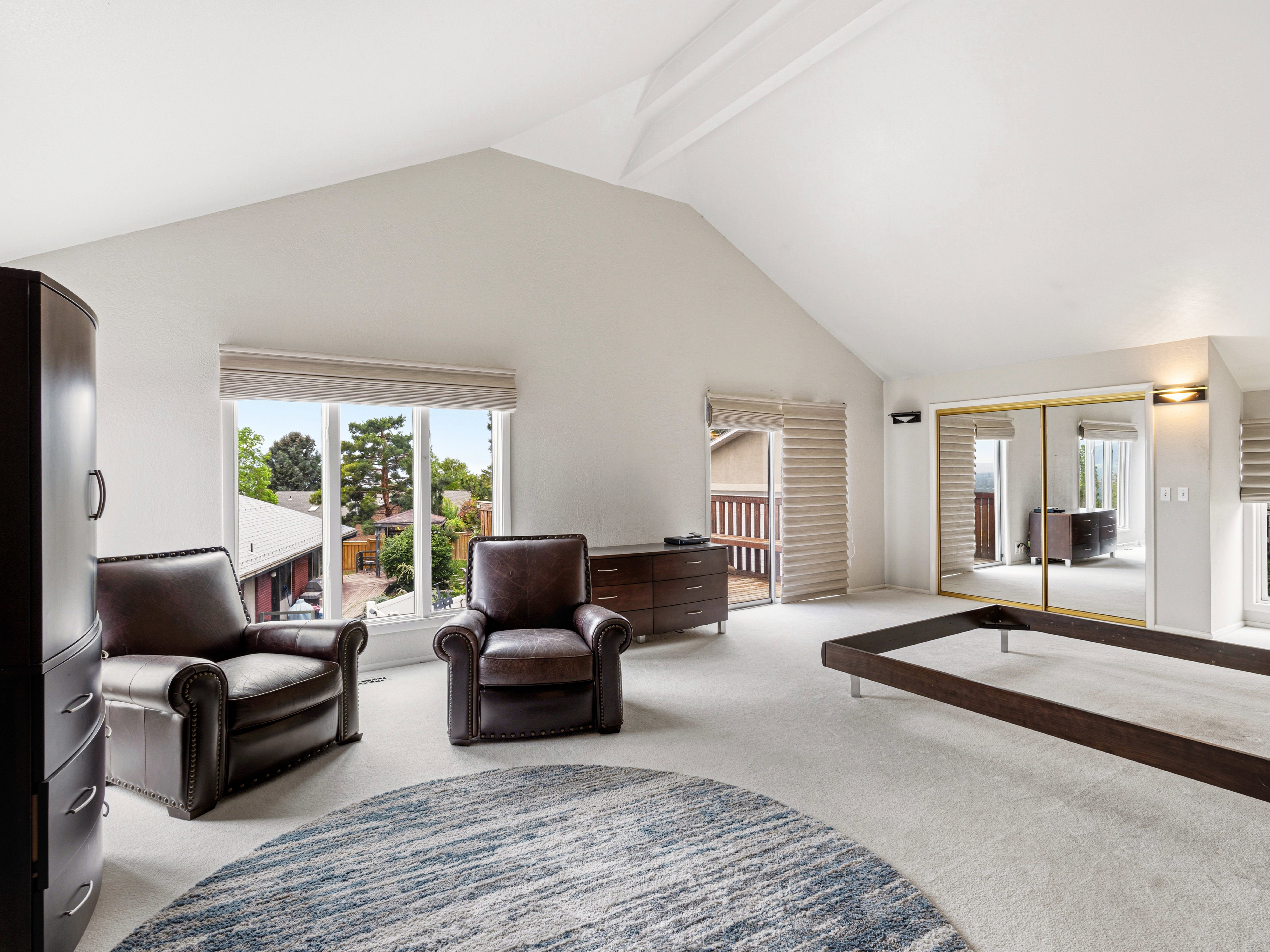 Vaulted ceilings highlight this expansive room featuring carpet flooring