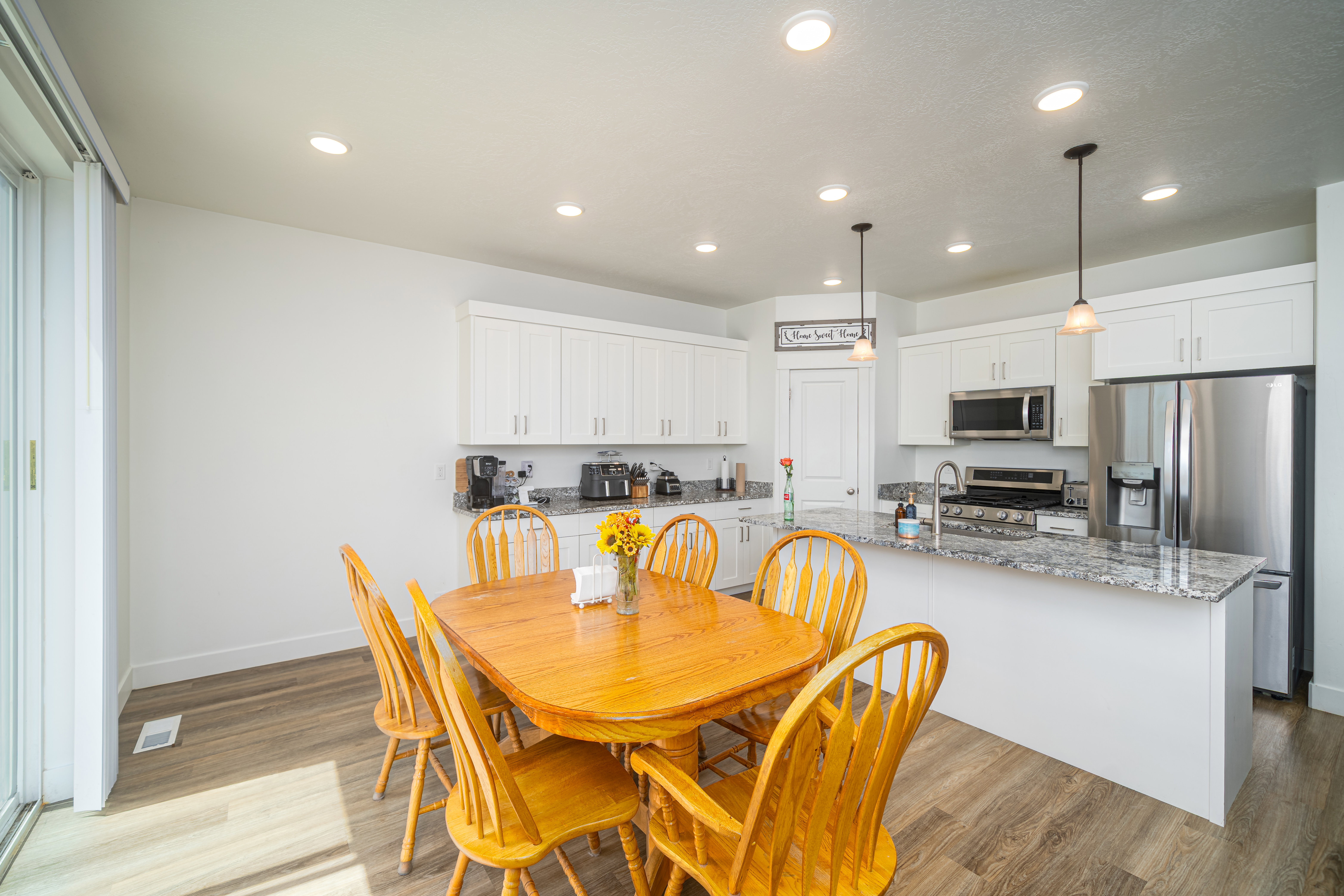 Kitchen with white cabinetry, stainless steel appliances, and stone countertops