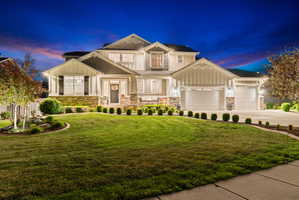 Two-story residence featuring a combination of horizontal siding, board and batten accents, and stone veneer