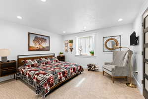 Spacious room featuring neutral carpeting, recessed lighting, and a window with white trim