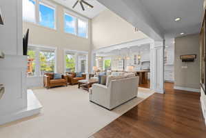Vaulted ceilings with an integrated ceiling fan, large windows with upper transoms, and a white fireplace hearth