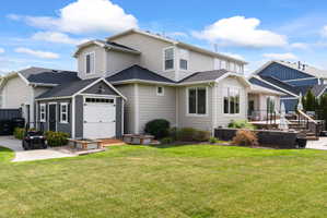 Expansive green lawn with a multi-level deck and a detached storage shed