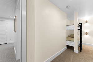 Built-in bunk beds featuring white paneling and a black metal ladder