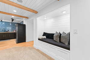 Built-in window seat with shiplap backing and recessed lighting, offering integrated storage