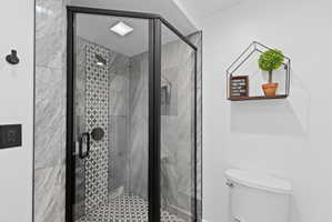 Glass-enclosed shower featuring dark-toned framing and hardware