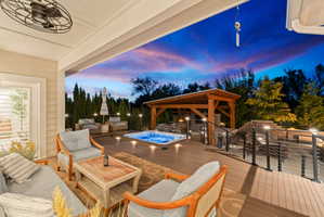 Expansive outdoor living area featuring a covered patio, multi-level composite decking, and a built-in spa