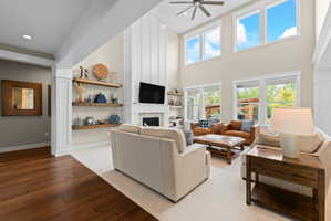 Spacious living area featuring a vaulted ceiling and wood-finish flooring