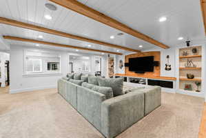 Spacious living area featuring exposed wood beams and recessed lighting