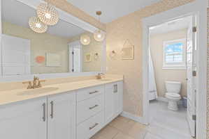 Double vanity featuring white cabinetry, light-toned countertops, and brushed nickel fixtures