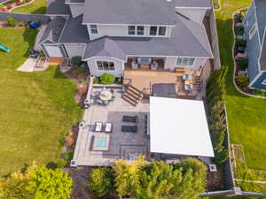 Rear exterior featuring a multi-level composite deck, paver patio, and covered outdoor living space