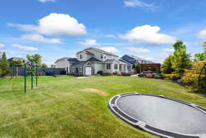 Expansive green lawn with established landscaping, including mature trees and shrubs