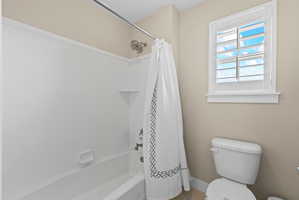 Tub and shower combination featuring a brushed nickel showerhead and faucet