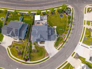 Expansive corner lot featuring mature landscaping, a concrete driveway, and a spacious backyard patio area
