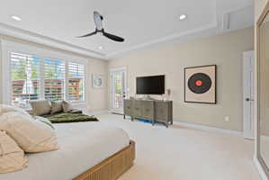 Spacious room featuring light-colored carpeting, a tray ceiling with recessed lighting and a contemporary ceiling fan, and large windows with plantation shutters