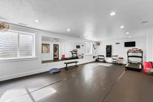Spacious room featuring dark-toned flooring, recessed lighting, and two windows