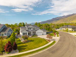 Contemporary two-story residence featuring a gray and white facade, dark gray roofing, and a prominent two-car garage