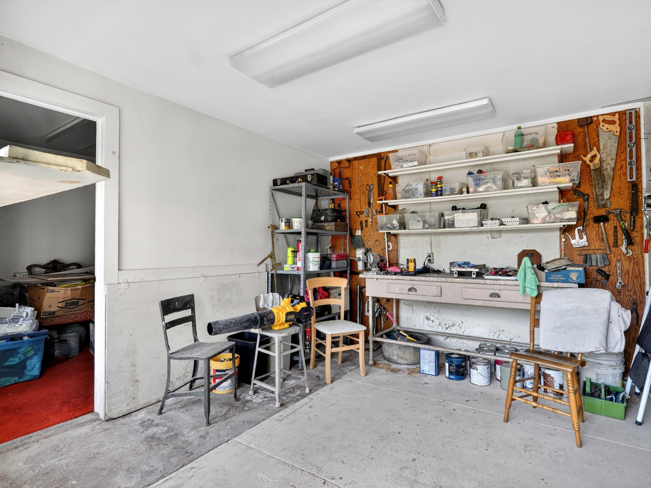 Utility space featuring concrete flooring, a built-in workbench.