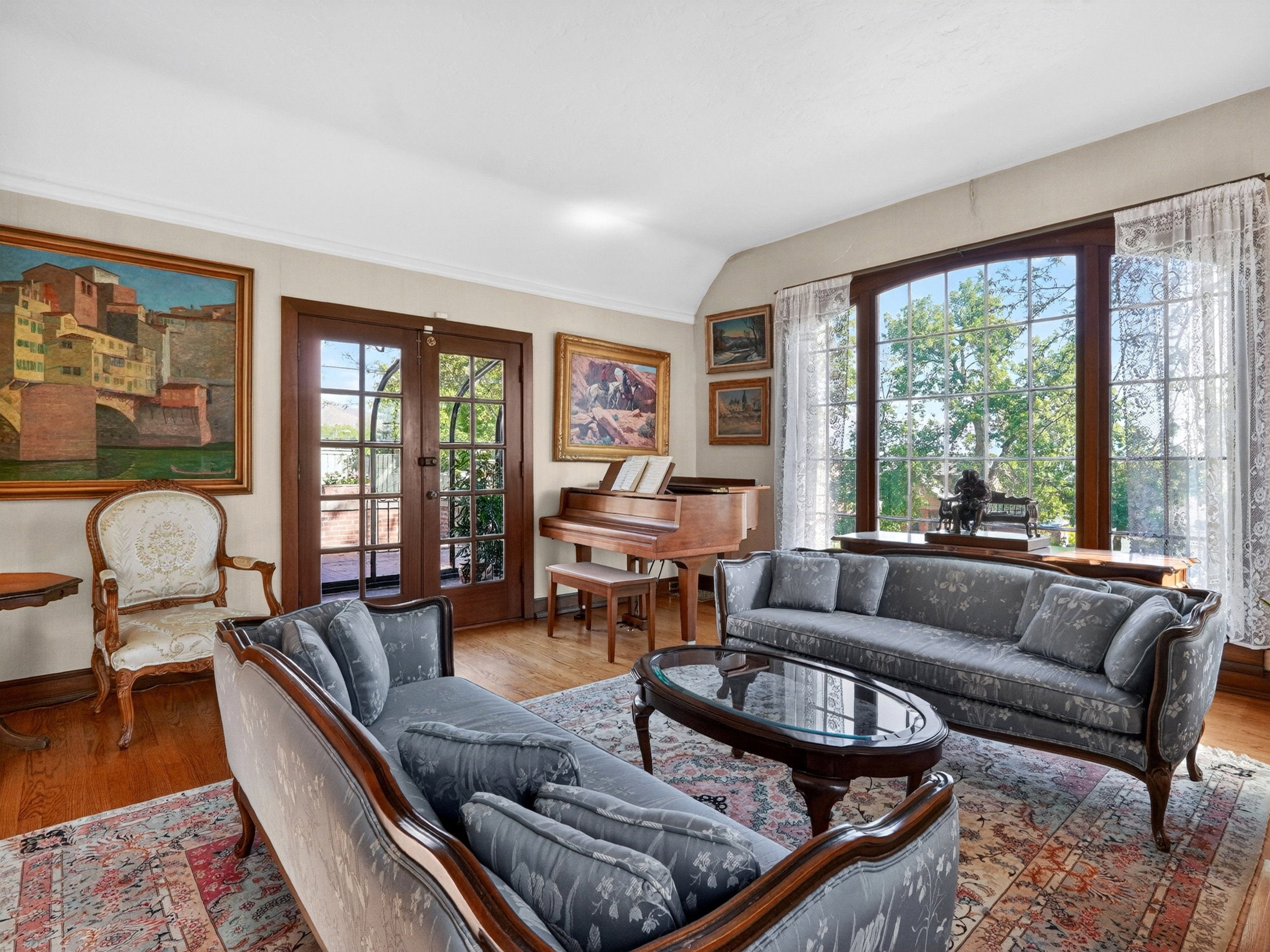 Living space featuring wood-finish flooring, a patterned area rug, and a wide picture window.