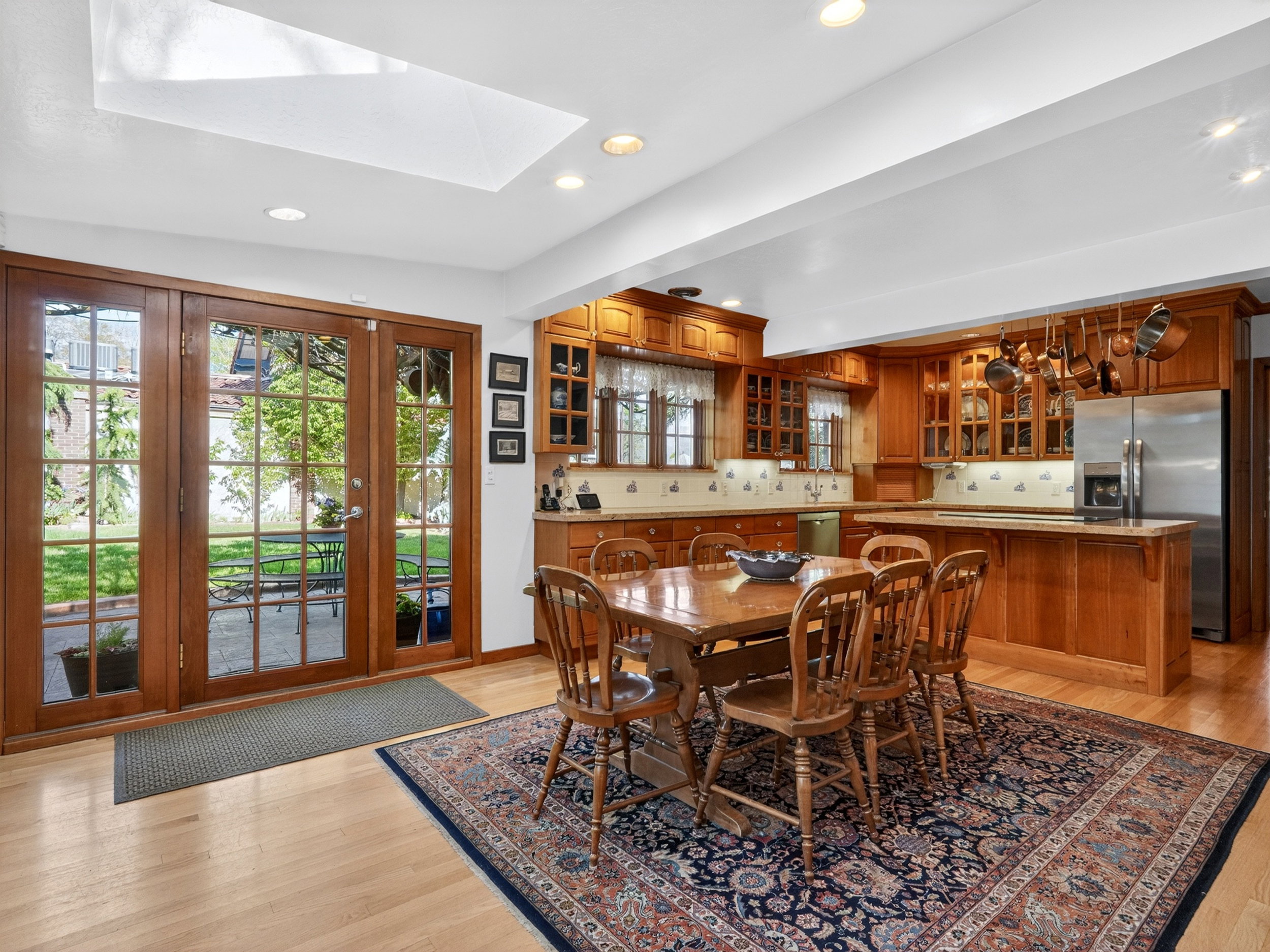 Spacious kitchen and dining area featuring light wood-finish flooring, warm-toned cabinetry, and a large central island