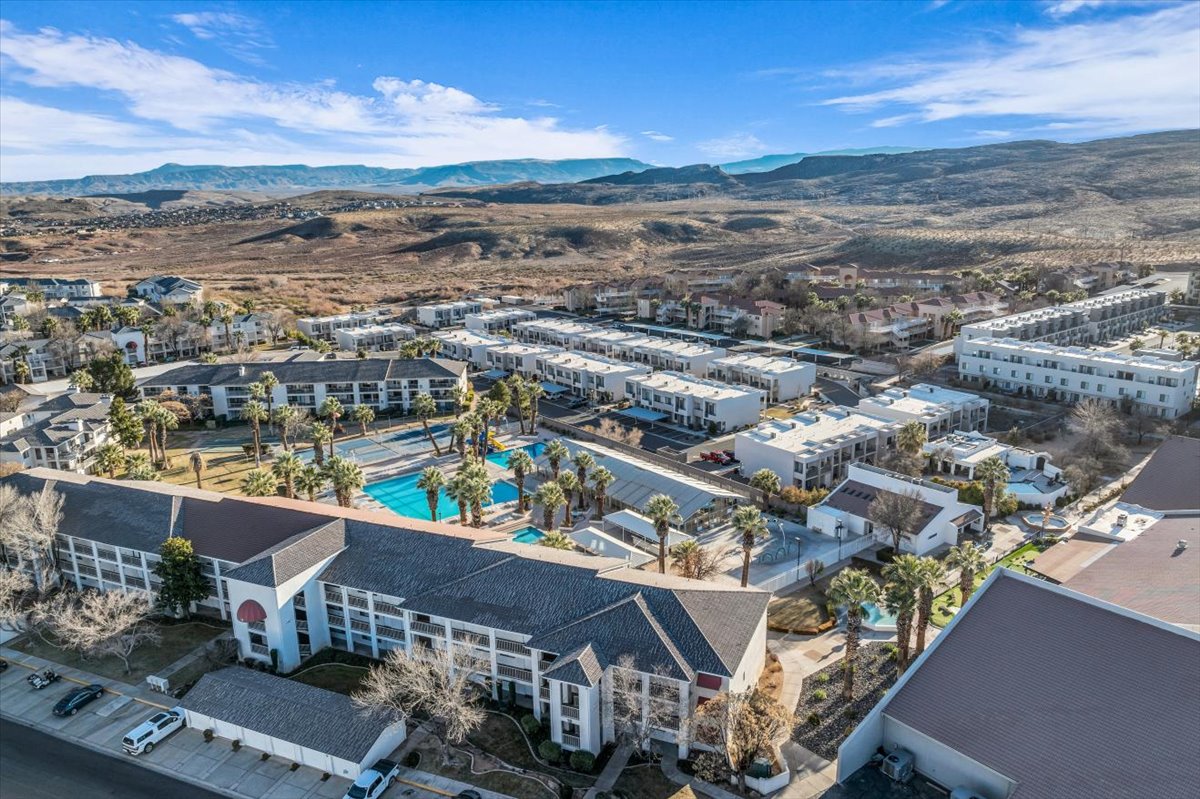 Community grounds featuring multiple swimming pools, tennis courts, and mature palm trees