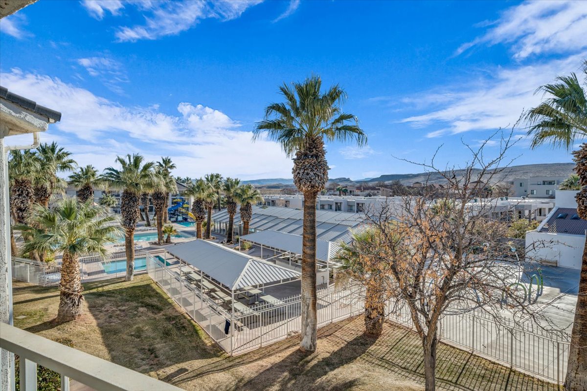 Resort-style pool area with multiple swimming pools, surrounded by mature palm trees