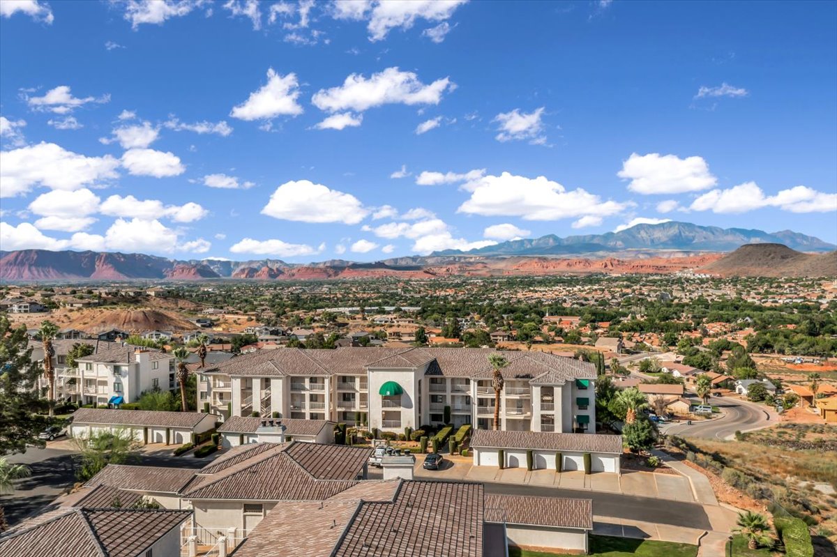 Multi-story residential complex featuring balconies, a tiled roof, and a green awning accent