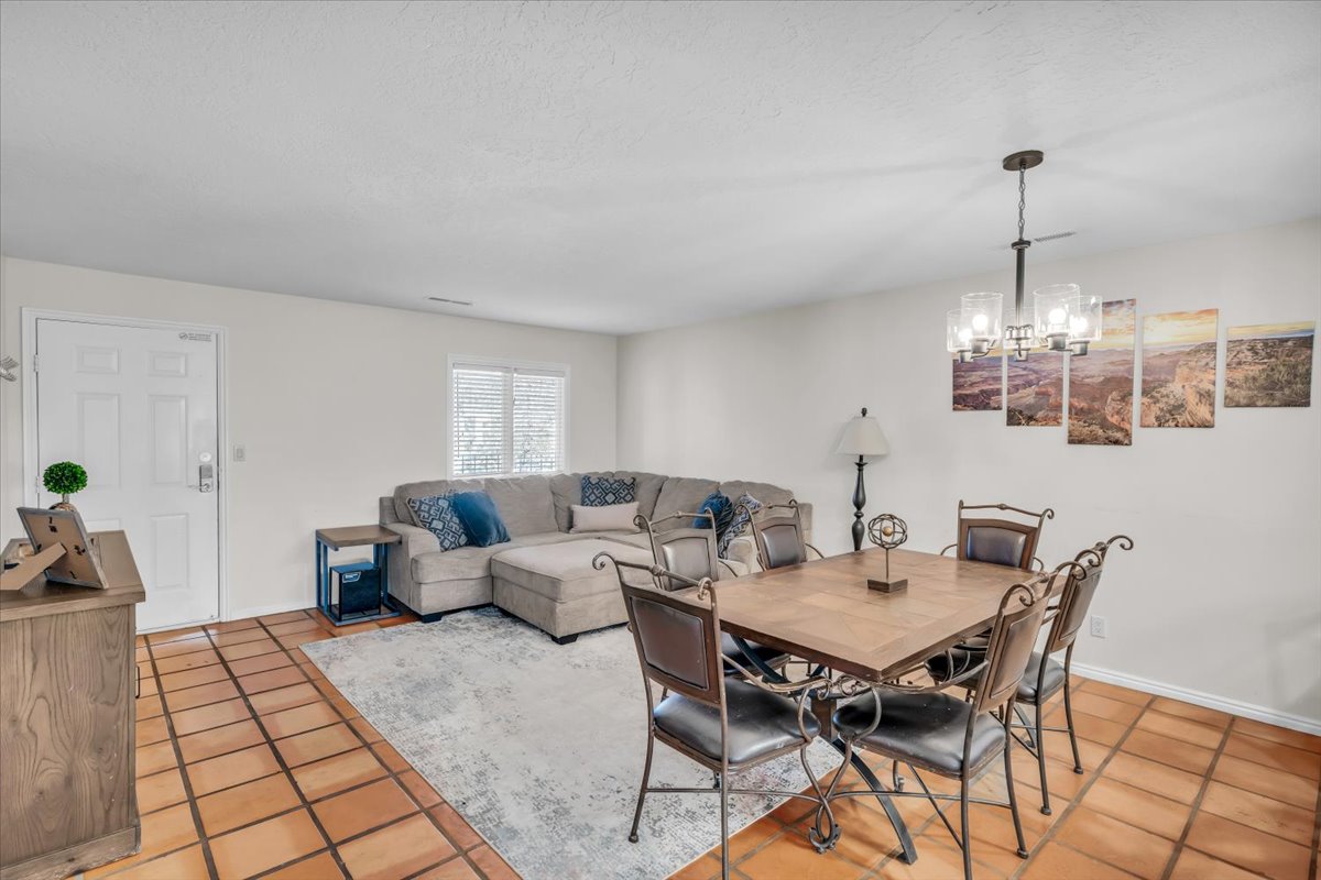 Open-concept living and dining area featuring terracotta-style tile flooring and a neutral color palette