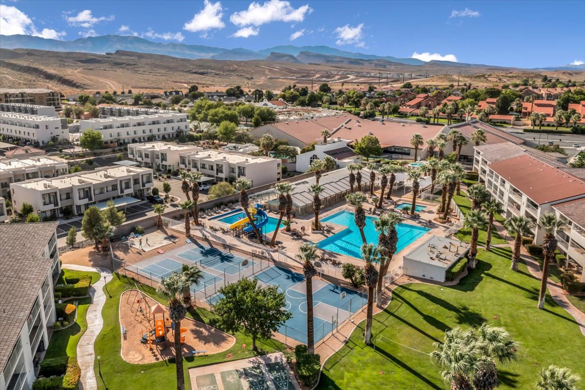 Expansive community featuring multiple swimming pools with slides, tennis courts, volleyball courts, and a playground