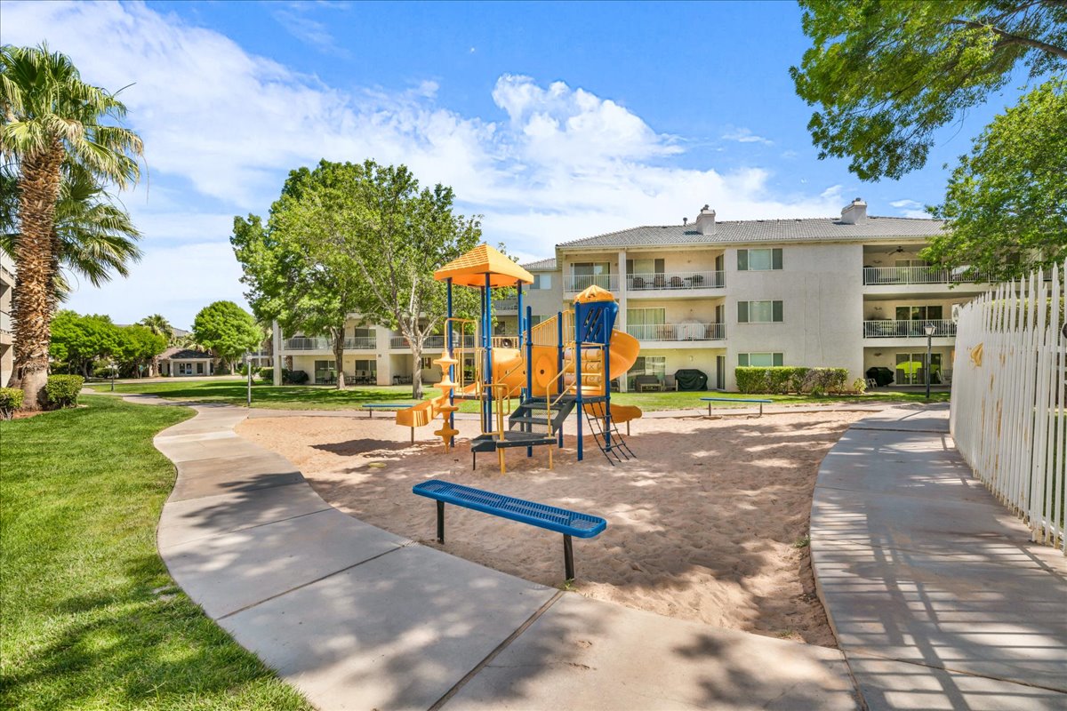 Recreational playground area featuring a multi-level play structure with slides and climbing elements set in a sandy base