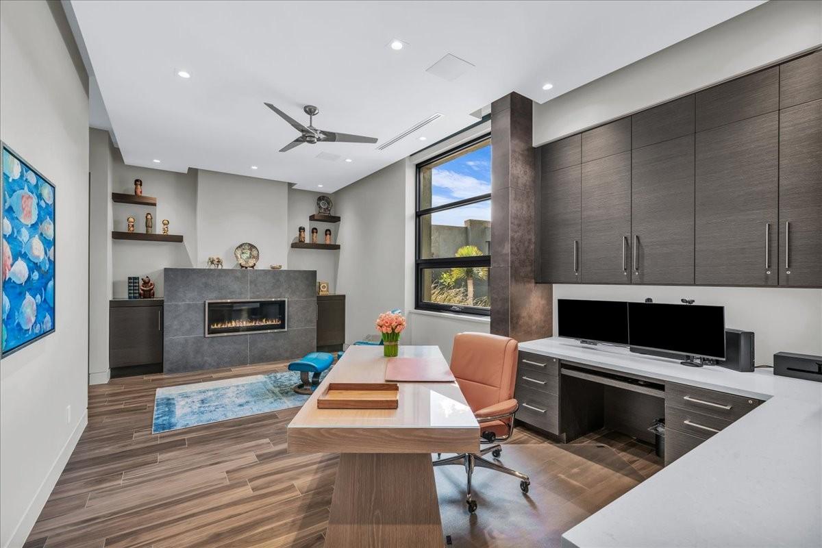 Wood-finish flooring throughout this room, featuring a modern linear fireplace with a dark stone surround