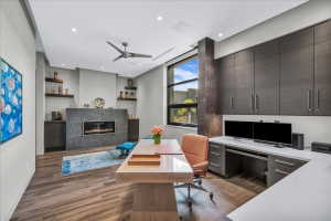 Wood-finish flooring throughout this room, featuring a modern linear fireplace with a dark stone surround